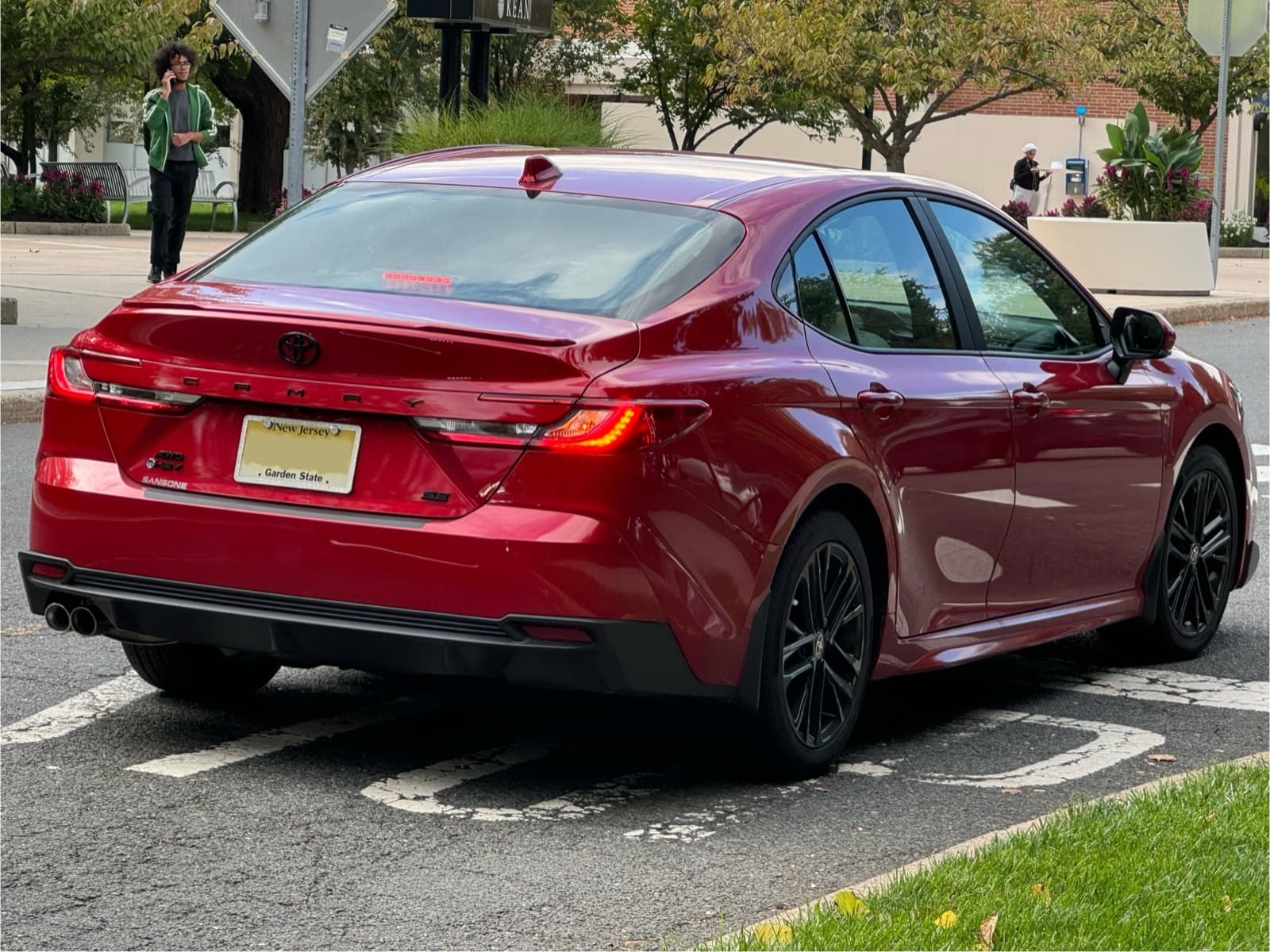 Rear three-quarter view of a red 2025 Toyota Camry SE